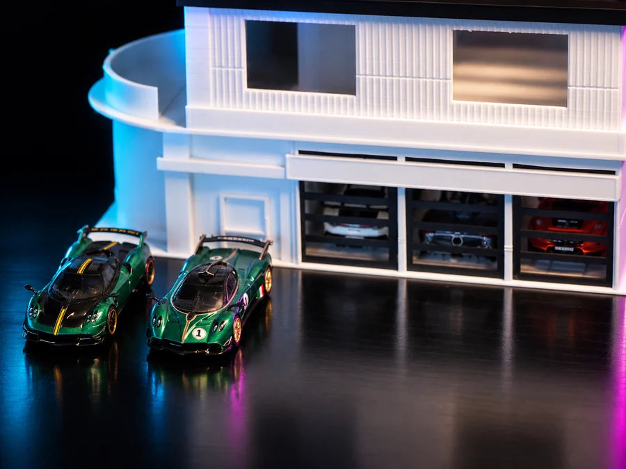 Frame 4 — low on the front, the curved wing and the three bays lit from inside, two cars out on the forecourt.