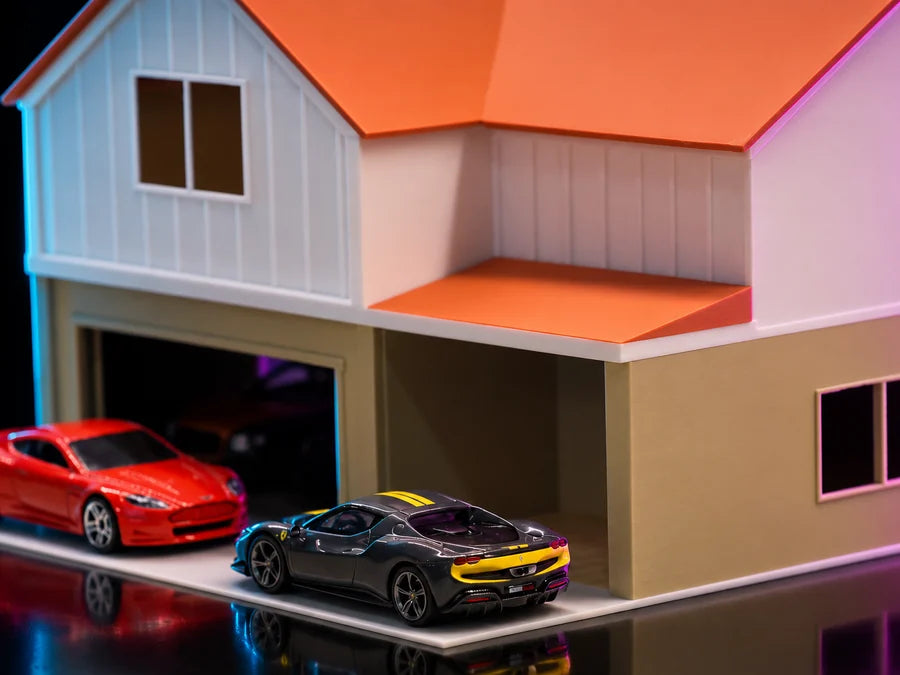 Frame 4 — low on the corner, close enough to read the board-and-batten gable above the open bay, two cars on the apron.