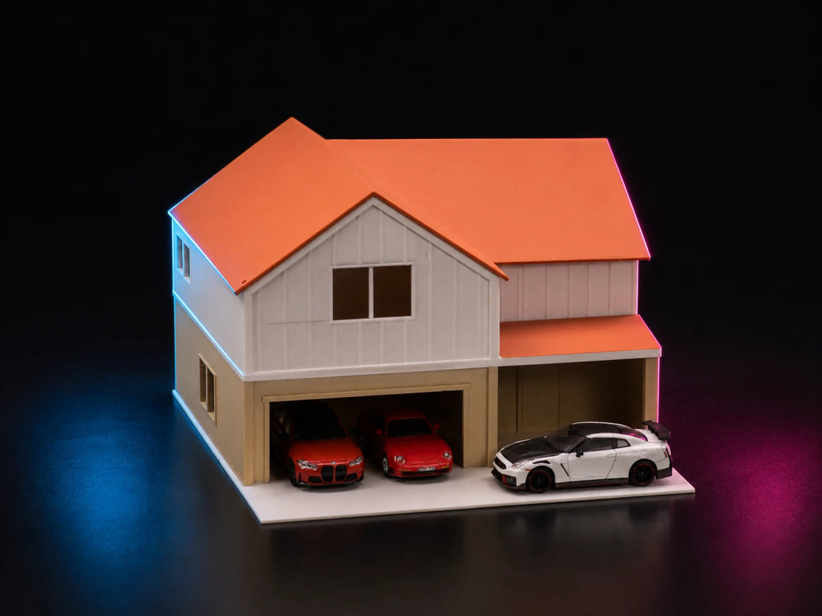A printed suburban house with an orange door, a pitched roof and a car parked on the drive.