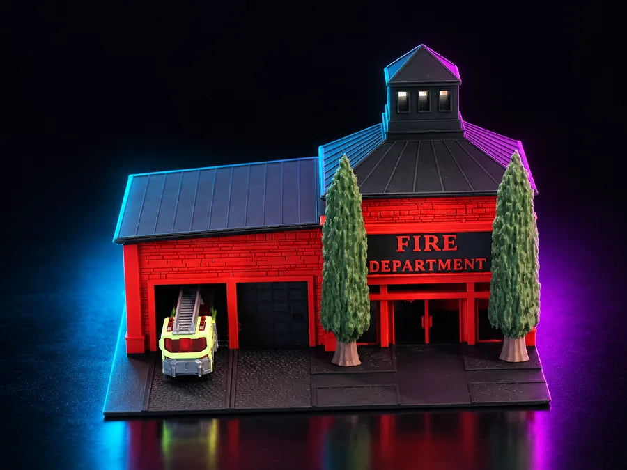 Frame 5 — the front three-quarter lit cyan and magenta, the ladder truck at the near bay and a tree either side of the FIRE DEPARTMENT sign.