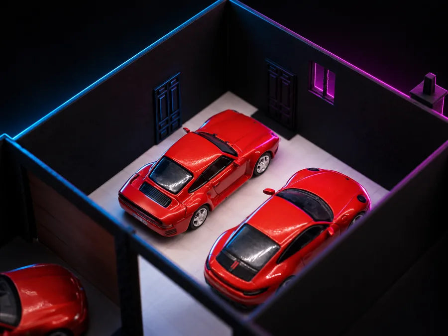 Frame 4 — the roof off and the bay open from above, two cars side by side inside it, a panelled door and a narrow window on the wall behind.