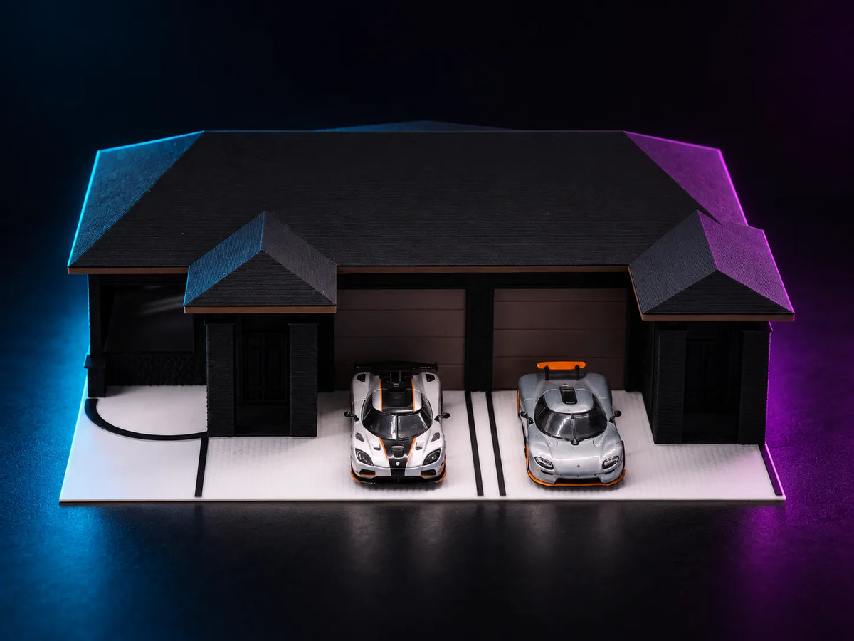 A printed single-storey house lit in blue and magenta, a wide dark hipped roof with a projecting hipped wing at each end, two ribbed sectional garage doors in the centre and a car standing on the pale apron in front of each.
