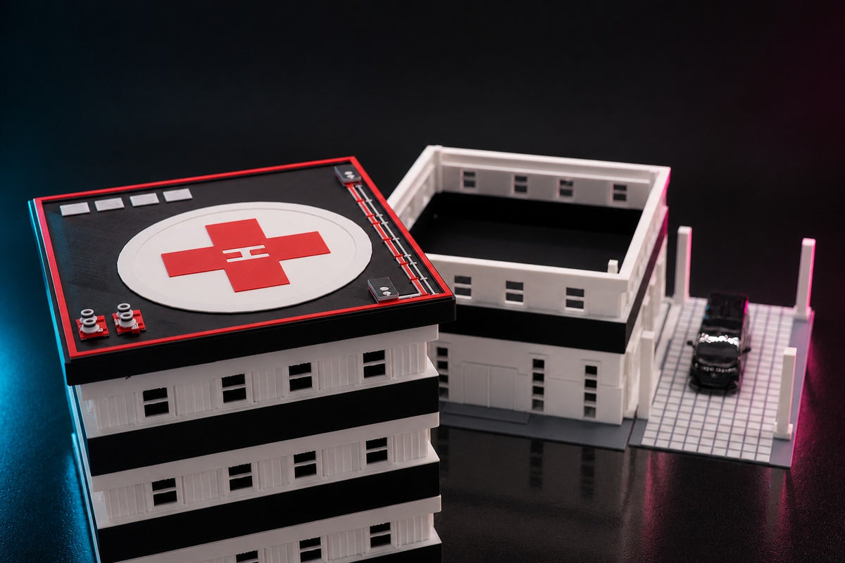 The 1:64 hospital opened up, helipad roof and upper floors lifted off beside the base, a van under the canopy