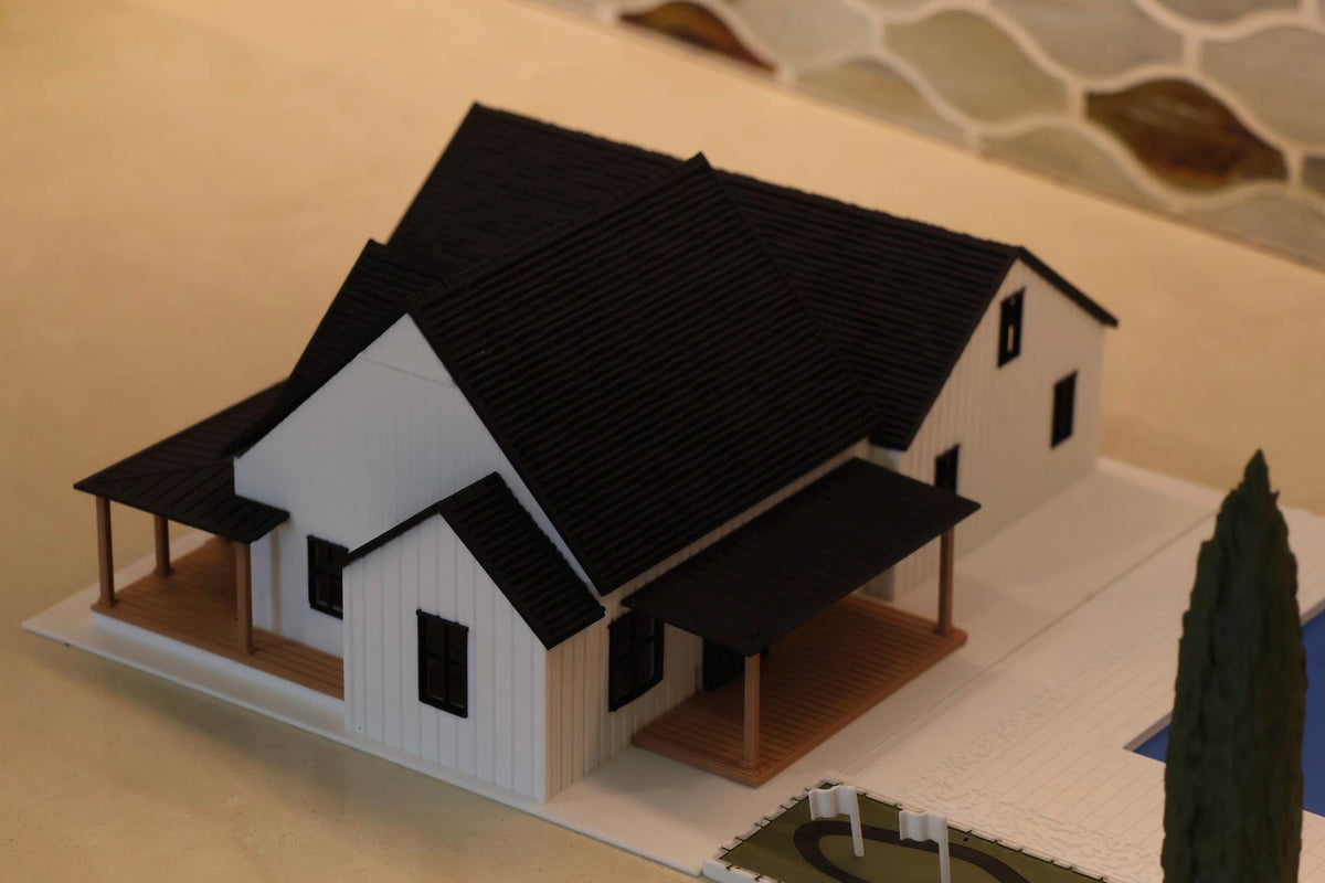 Overhead view of the black tiled roofs and wood-tone porches on the 1:64 modern farmhouse