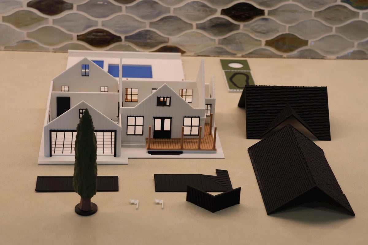 The 1:64 modern farmhouse diorama laid out in its separate pieces, with the cypress tree and flags