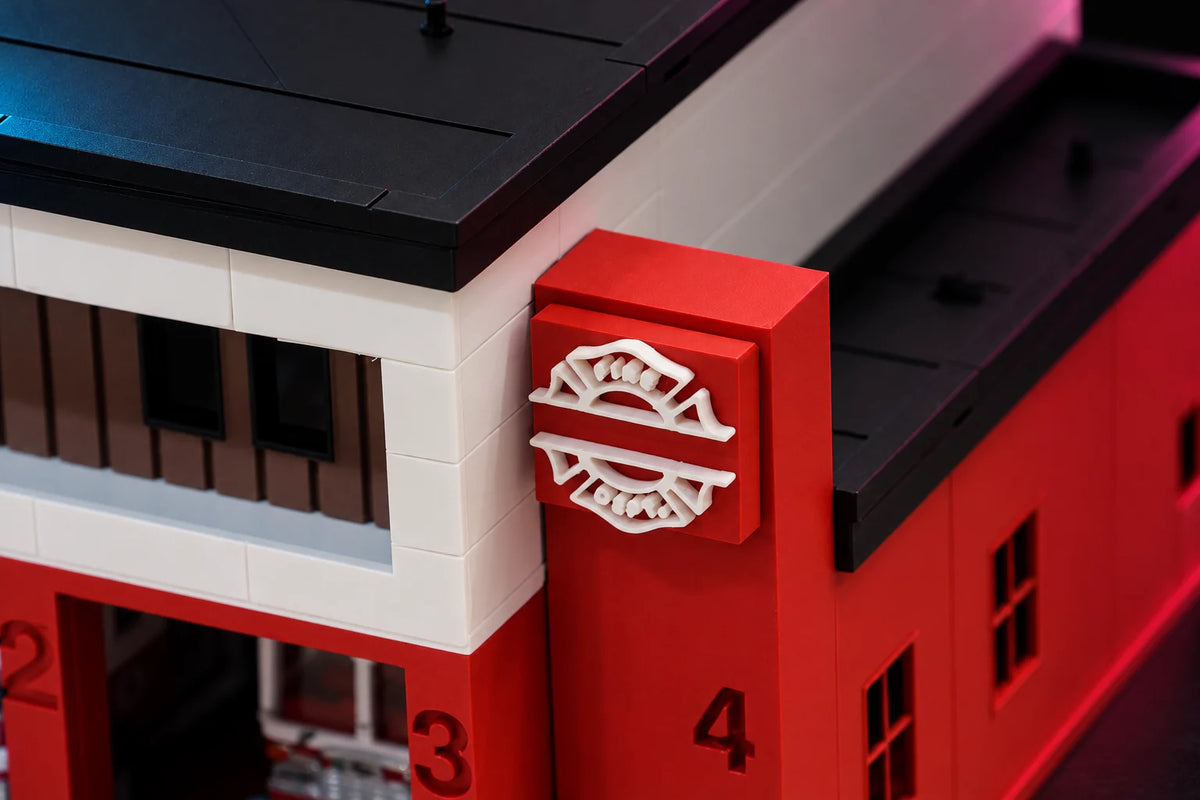 Close-up of the raised FIRE DEPT. Maltese cross sign on the red corner tower of the 1:64 fire station