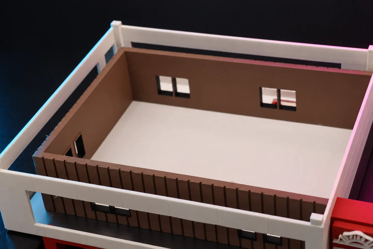 Roof lifted off the 1:64 fire station diorama, looking down into the upper floor with brown board-and-batten walls
