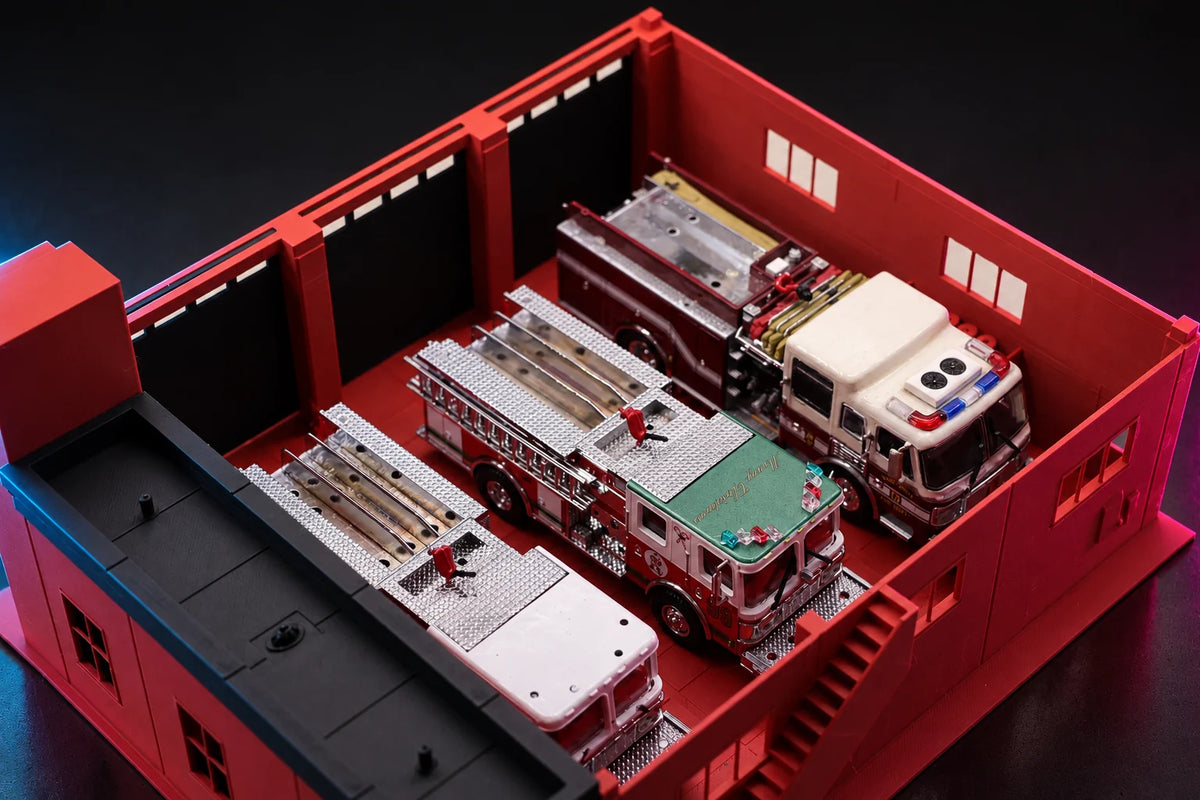 Upper floor removed from the 1:64 fire station, three diecast fire engines parked on the red apparatus floor