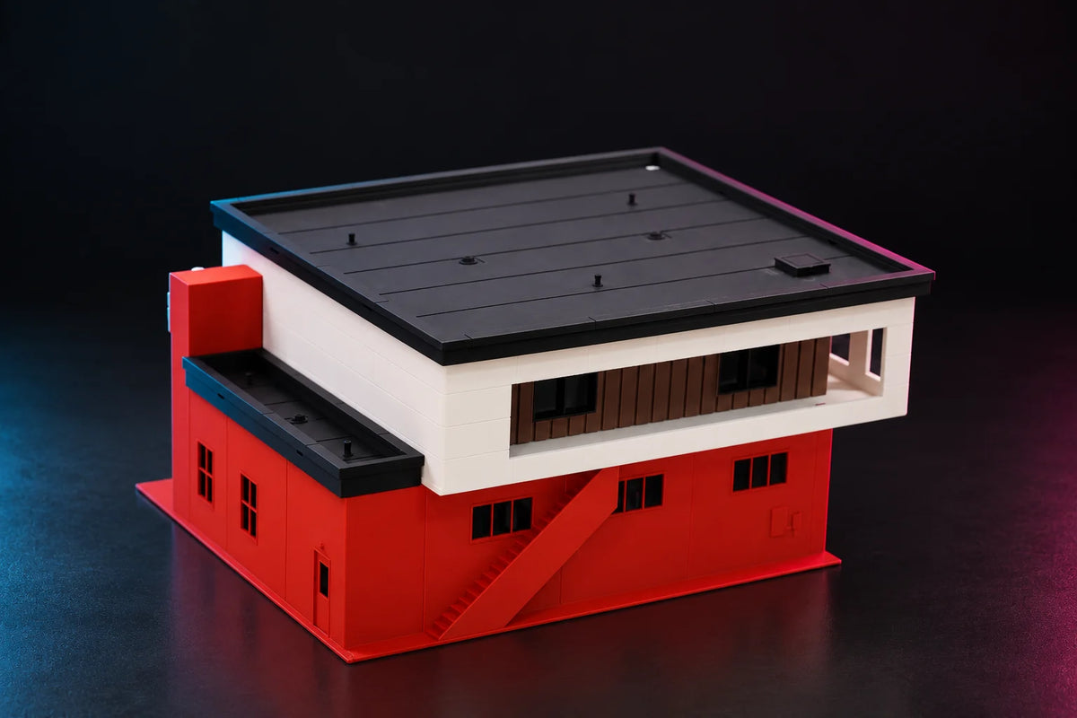 Rear three-quarter view of the 1:64 fire station, the lower side wing with its black roof beside the two-story block