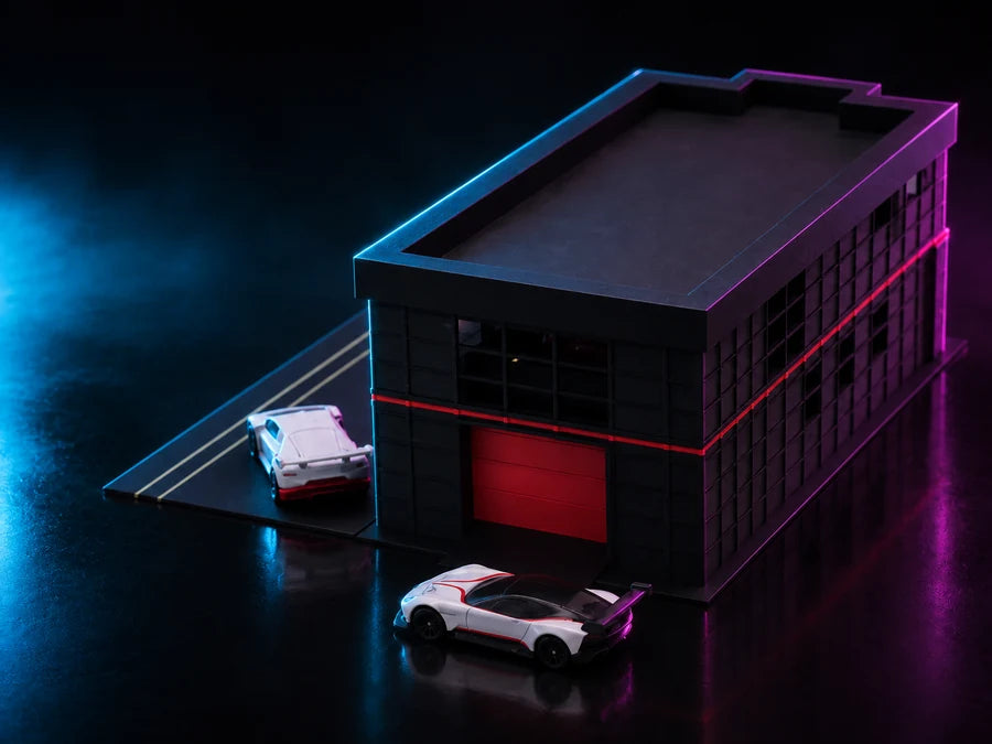 Frame 2 — high on the front corner, the apron ramp running off to the left and a white GT car stopped at the lit roller door.