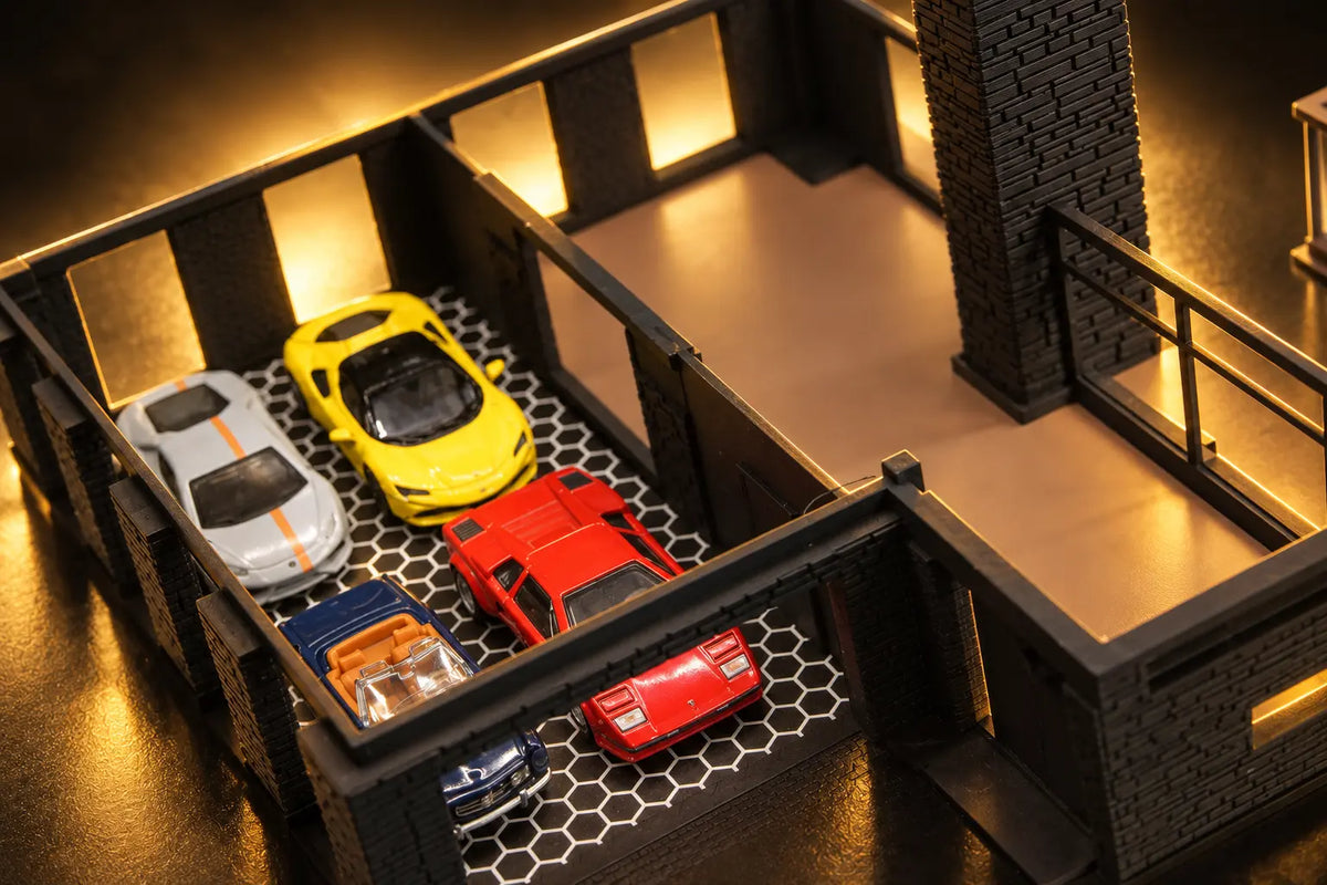 The ground floor from above with the upper floor lifted off: four cars in the garage on the hexagon floor, the open living space and the chimney beside it.
