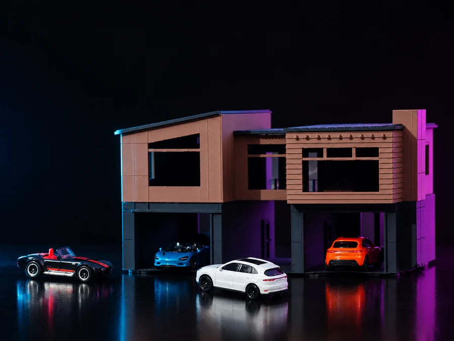 The Two-Story Modern build lit in cyan and magenta, both garage bays open with cars on the drive and more parked along the plate.