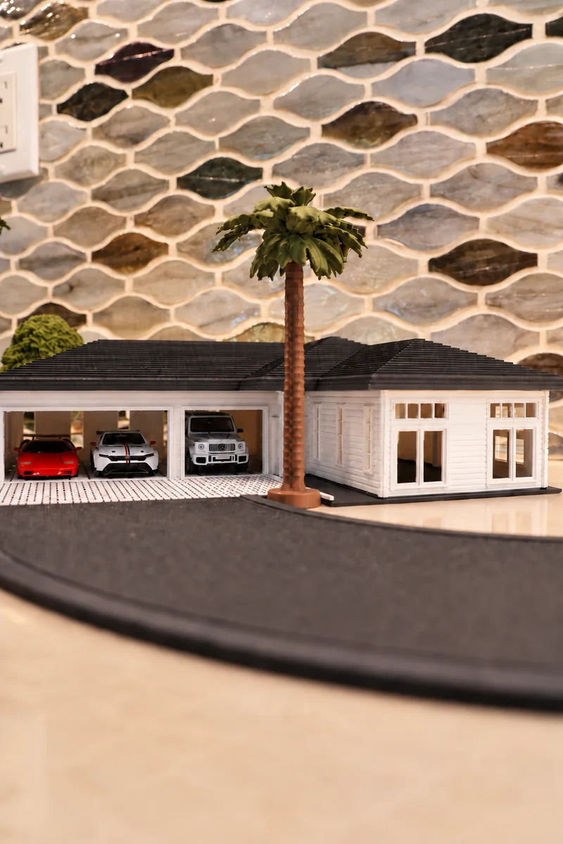 The same house again with the camera down near the deck: the two open bays face the lens almost square on with the cars clearly visible inside, the roof reduced to a thin band, and the palm standing right up the frame.
