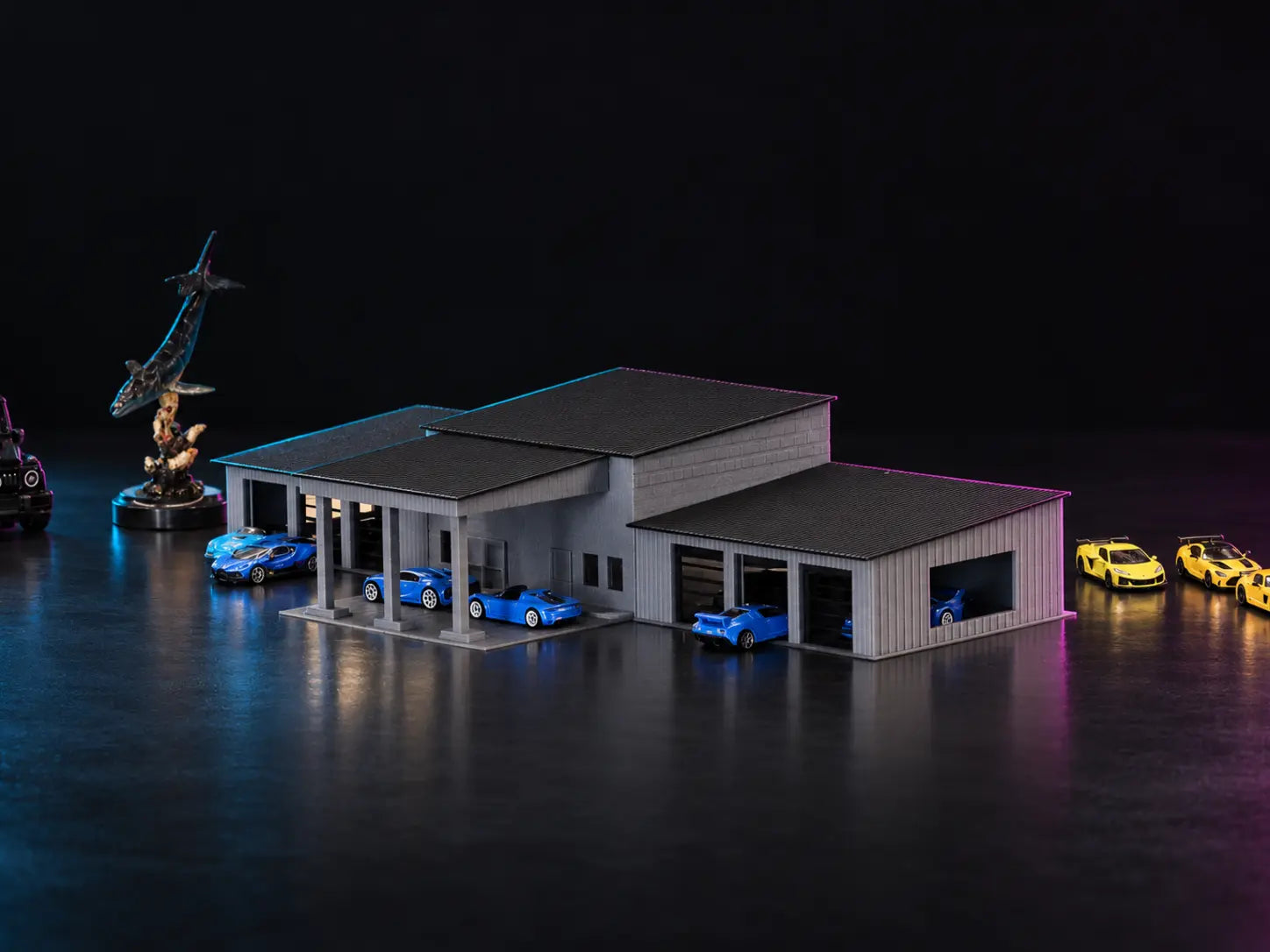 The printed collector garage in grey under dark roofs, blue cars under the columned carport and in the bays, lit cyan and magenta.