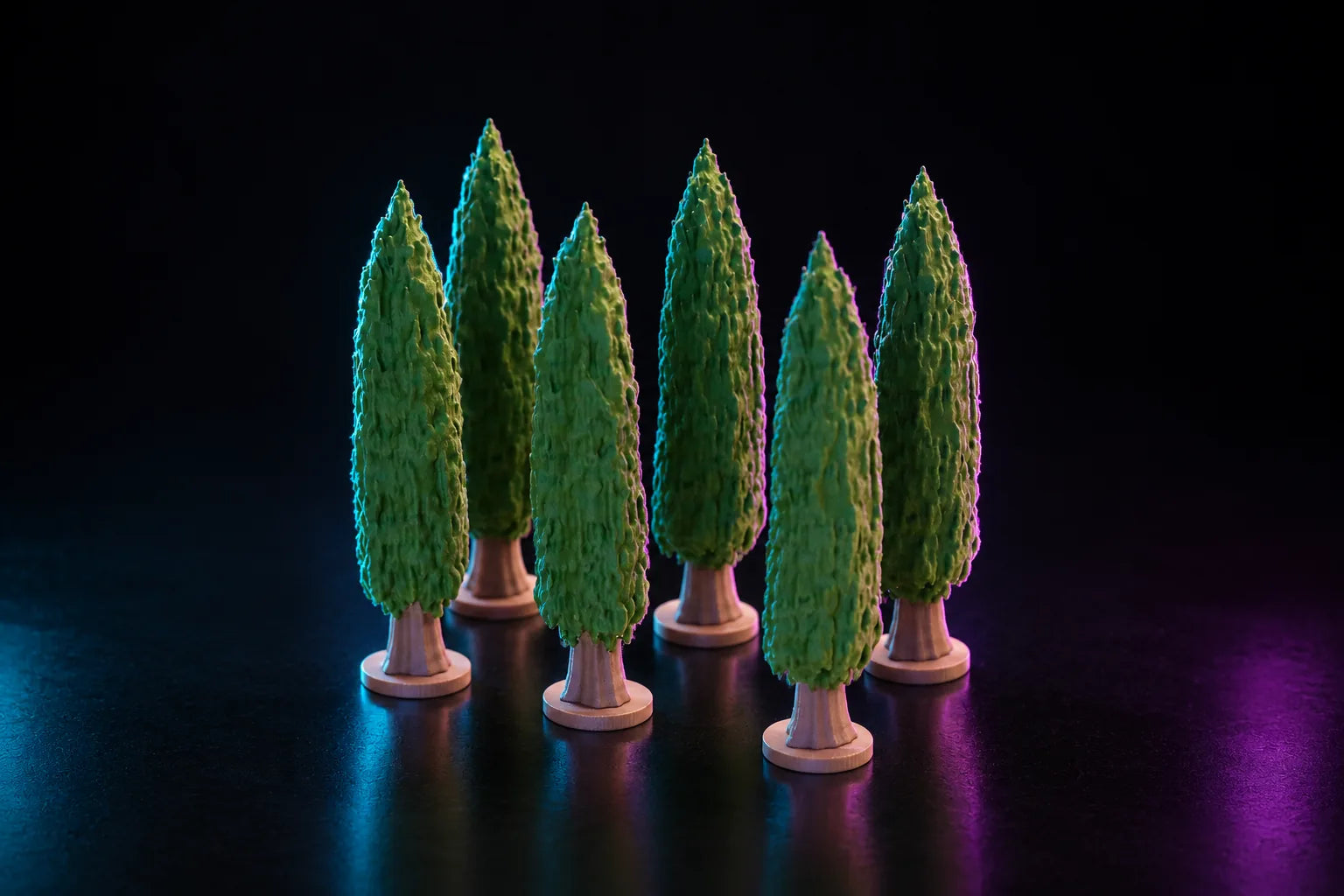 A group of printed cypress trees lit in cyan and magenta on a dark reflective floor, each a tall narrow column of textured foliage on a bare trunk and a round stepped base.
