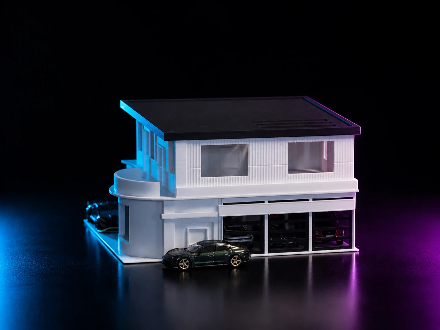 A printed modern mansion in white and grey, lit cyan and magenta, with a black car on the driveway.