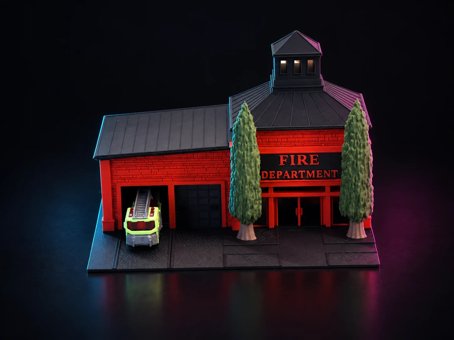 A printed two-bay fire station in engine red with a pitched charcoal roof, a louvred hose tower over the entrance and FIRE DEPARTMENT across the front, lit blue and magenta.