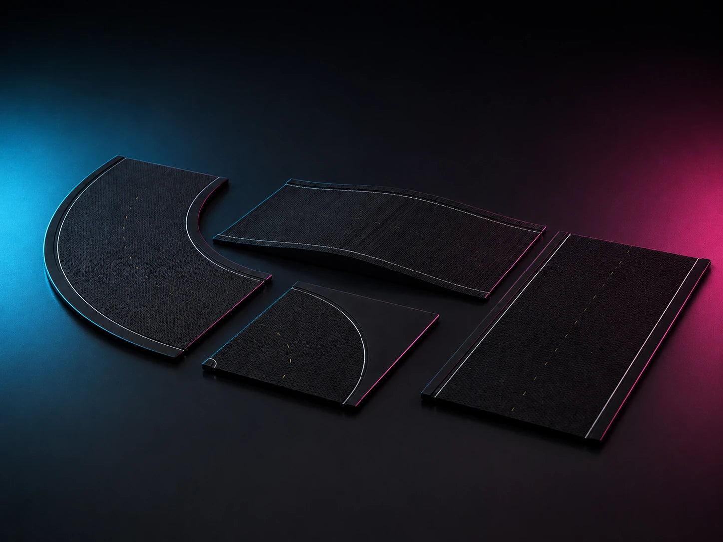 Four printed black road tiles laid out on a dark surface: a curve, an S-bend, a corner and a straight.
